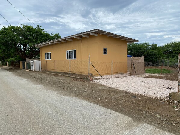 A small, single-story building with a flat roof and a fenced perimeter. - One Bedroom Apartment on Bonaire in Quit Area (Kralendijk)