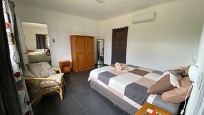 Une chambre à coucher avec un lit, une armoire, une petite table et une chaise.