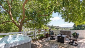 Un jacuzzi, mobiliario de exterior y vistas del paisaje.