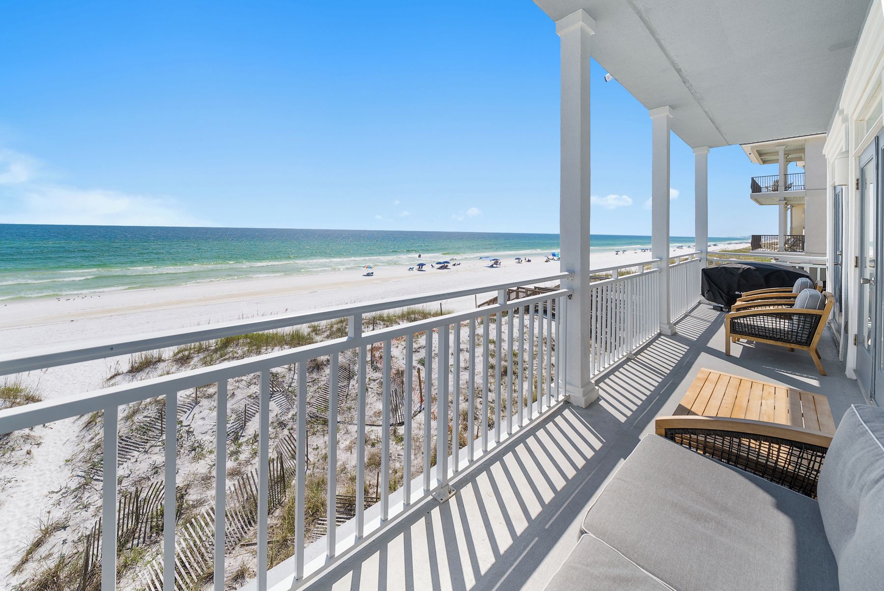 Ein Balkon mit Blick auf Strand und Meer.