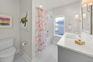 Et moderne badeværelse med bruser, toilet og håndvask.