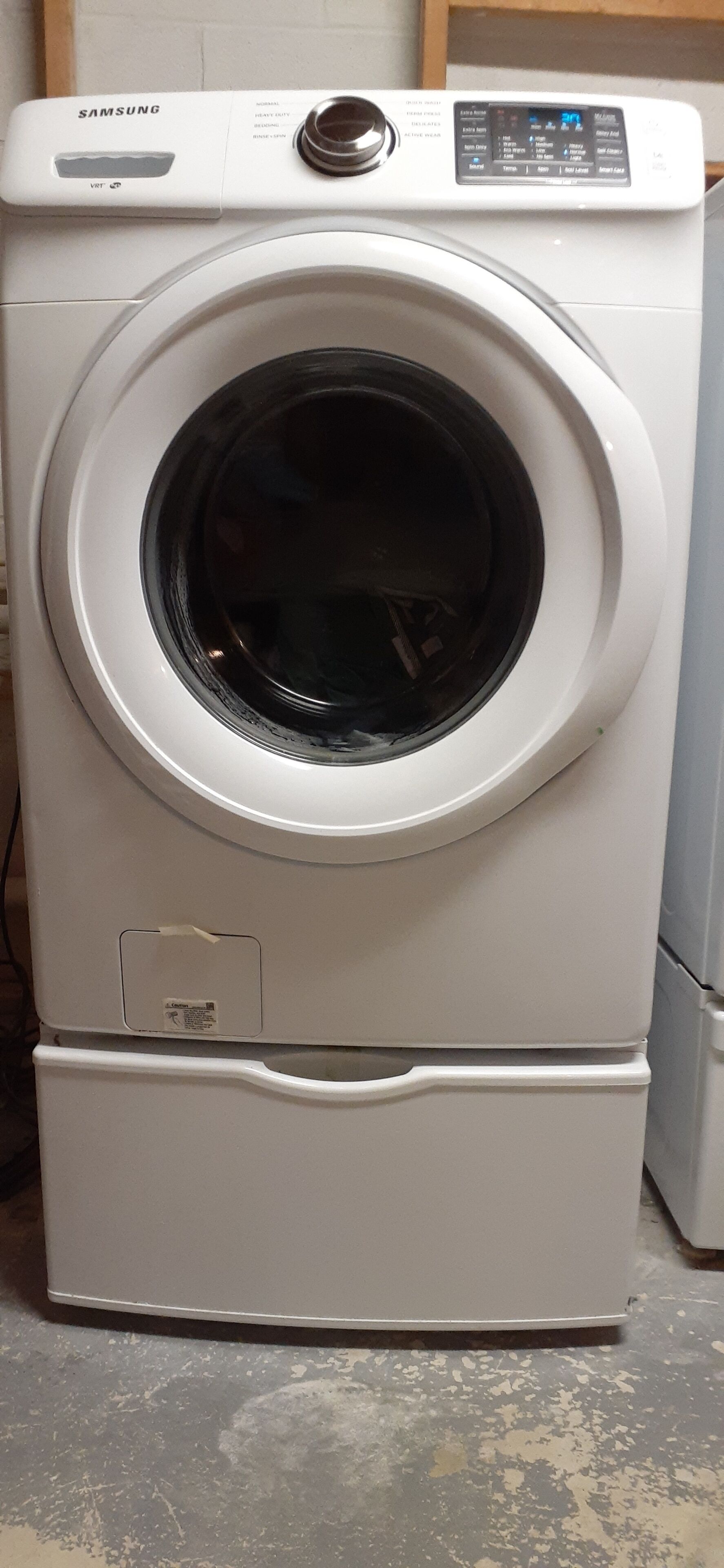 Een witte Samsung voorlader wasmachine met bedieningspaneel en digitaal display.