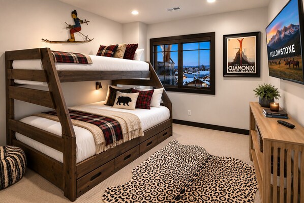A bunk bed with a ski-themed headboard, a window with a view, and a poster of Yellowstone.