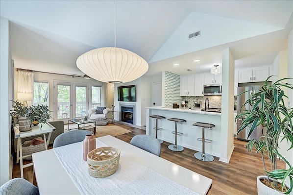 Enjoy meals at the large dining table surrounded by comfortable seating and modern kitchen amenities.