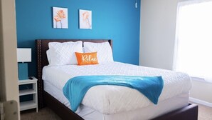 Une chambre à coucher avec un lit, une table de chevet et une fenêtre.