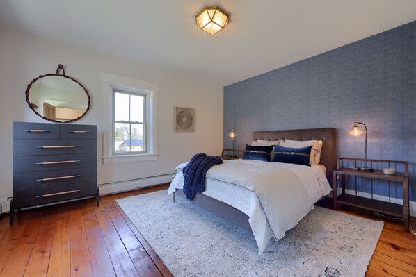 Une chambre à coucher avec un lit, une commode et des tables de chevet.