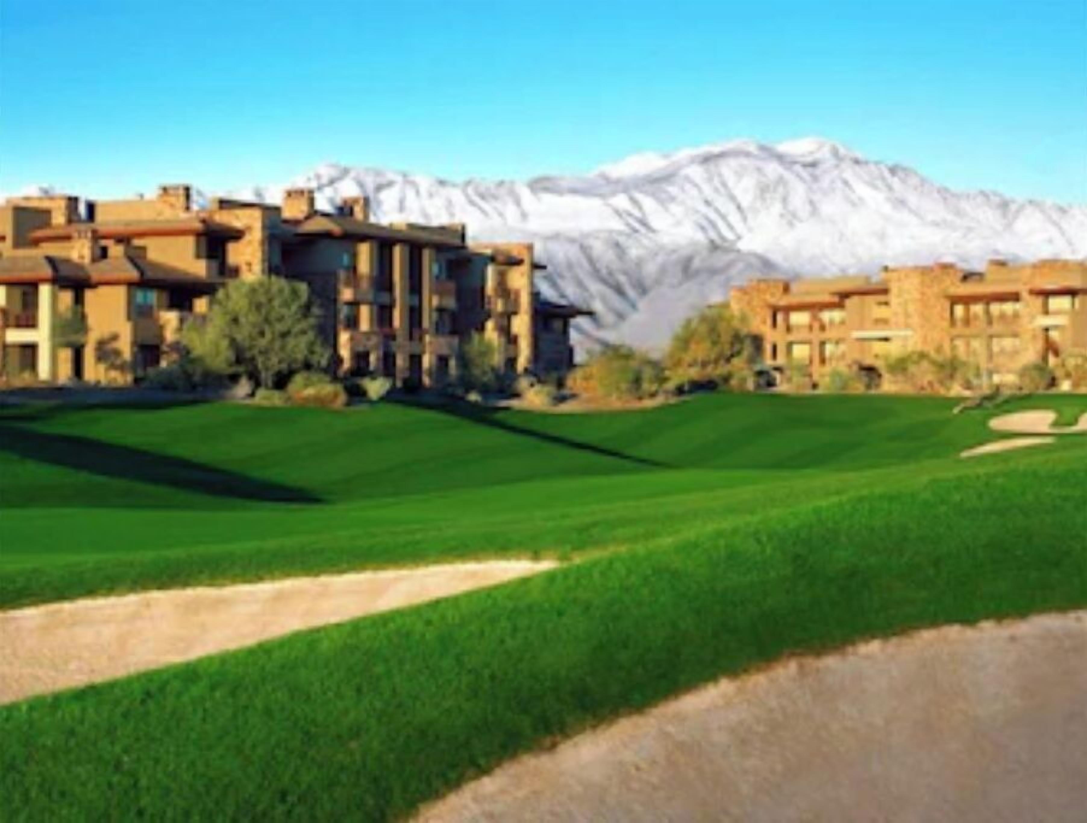 A golf course with a clubhouse and a mountain backdrop.