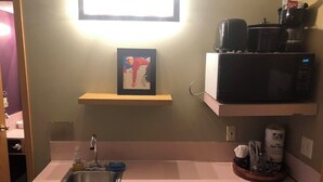 A kitchen with a stainless steel sink, a microwave, and a shelf with a framed picture. - Ski in/out room  with Queen and Full futon.  Sleeps 4 (Eden)
