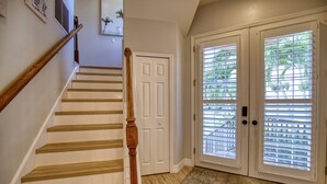 A staircase with wooden steps and a wooden handrail, leading to a white door with a doorknob. - 4 Bedroom Pool Home Siesta Key (Siesta Key)