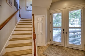 A staircase with wooden steps and a wooden handrail, leading to a white door with a doorknob. - 4 Bedroom Pool Home Siesta Key (Siesta Key)