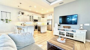 A modern kitchen with white cabinets, a central island, and a built-in microwave. - 4 Bedroom Pool Home Siesta Key (Siesta Key)