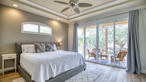 A bedroom with a large bed, a ceiling fan, a window with curtains, and a view of the outdoors. - 4 Bedroom Pool Home Siesta Key (Siesta Key)