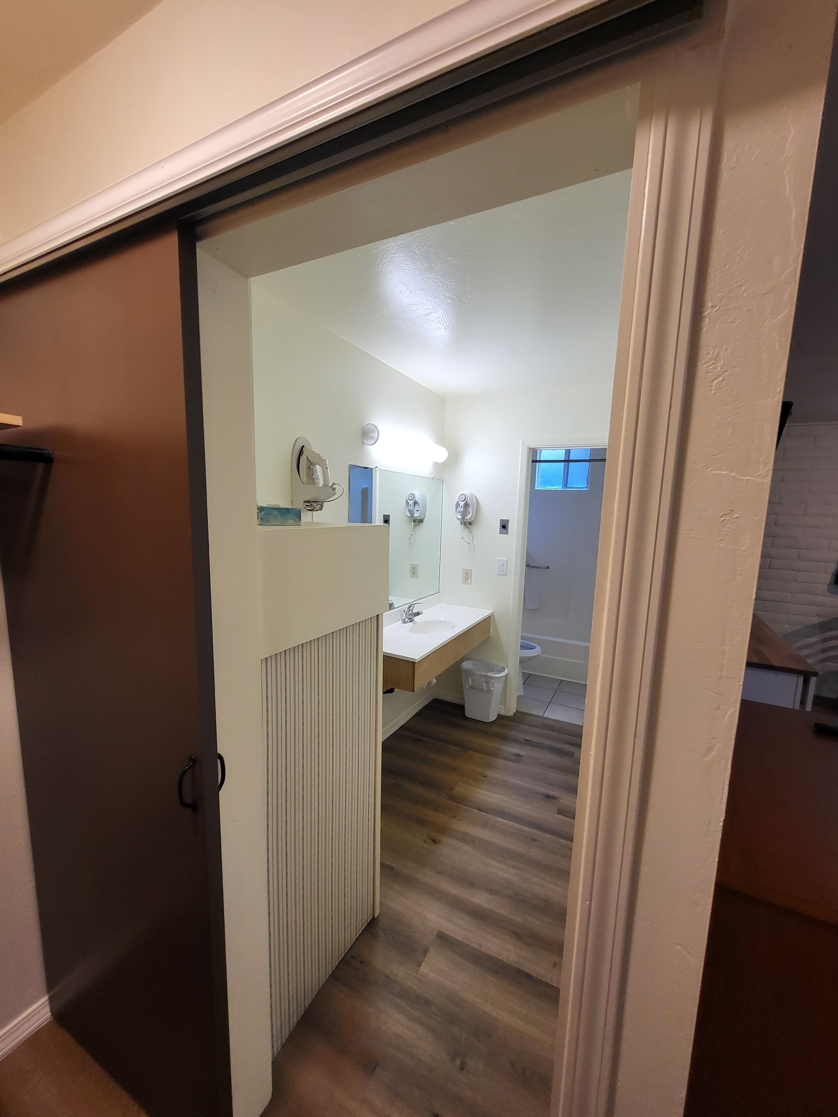 A bathroom with a white sink, a mirror, and a toilet.