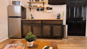 A compact kitchen with a refrigerator, microwave, and a coffee maker on the counter. - The Nook Pinetop (Pinetop)
