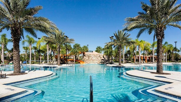 A large, clear swimming pool surrounded by palm trees, with a rock formation in the background. - Beautiful home-private spa/pool 5BD 5.5 BA (Davenport)