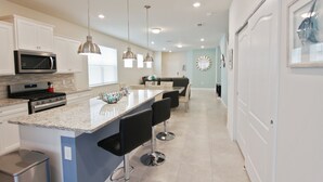 A modern kitchen with granite countertops, stainless steel appliances, and pendant lighting. - Beautiful home-private spa/pool 5BD 5.5 BA (Davenport)