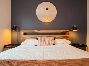 2 habitaciones, escritorio y tabla de planchar con plancha