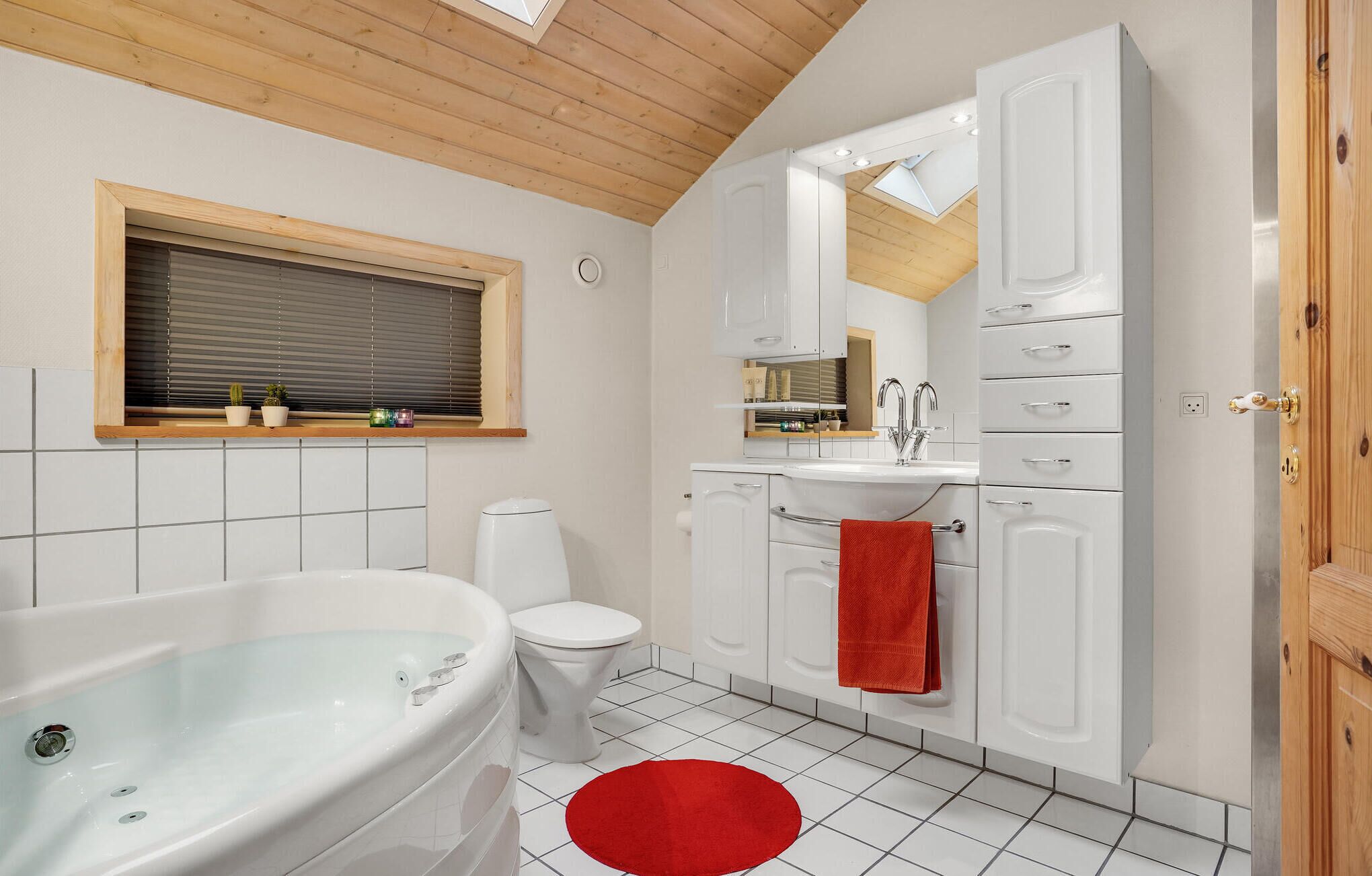 Een moderne badkamer met een bad, toilet en wastafel.