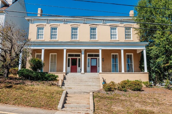 A two-story house with a front porch, a red door, and a number 453 on the door.