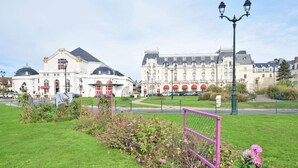 A large, historic building with a dome and red awnings, surrounded by well-maintained gardens and a clear sky. - 1 bedroom stunning apartment in Cabourg (Cabourg)