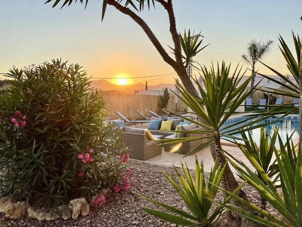 A pool area with lounge chairs and a sunset view. - 5mn Beach, Swimming pool, Sea view, Exotic garden, Air-conditioned, Ideal for families. (El Cocon)