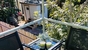 A balcony with two chairs, a small table, and a potted plant.