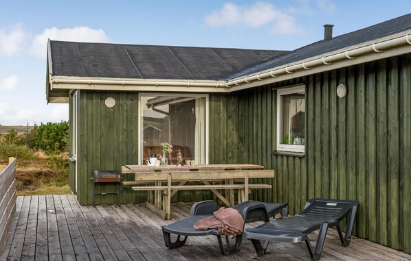 Enjoy a peaceful retreat with a cabin featuring a large window, deck, and comfortable seating.