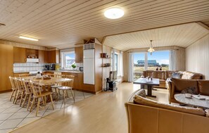 Enjoy a spacious interior with a high ceiling, dining area, kitchen, and seating area with a sofa.