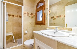 Ein Badezimmer mit Dusche, Toilette und Waschbecken.