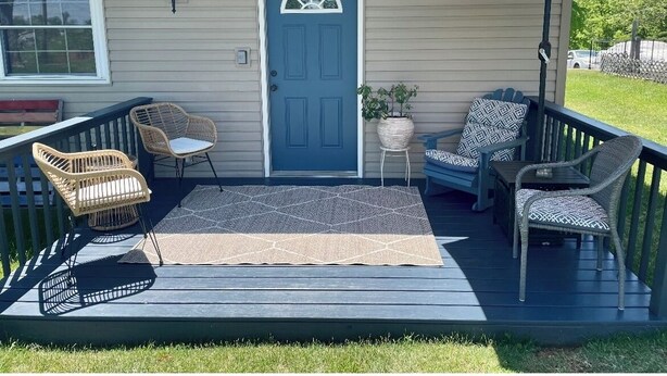 A covered porch with wicker chairs, a blue door, and a large umbrella. - Cozy 3 bed, 2 bath home close to historic downtown Hannibal (Hannibal)
