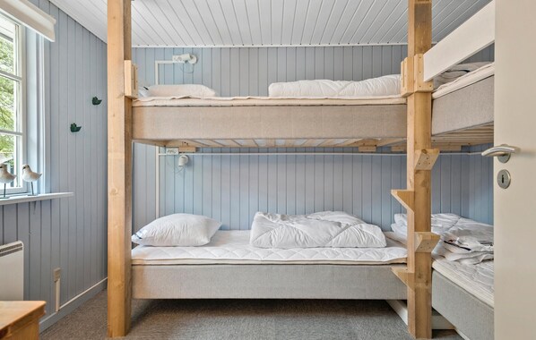 Ein Mehrbettzimmer mit zwei Etagen, einem Fenster mit Blick und einer Heizung.