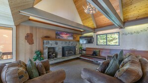 Una sala de estar acogedora con chimenea, techo de madera y asientos cómodos.
