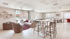 Un espace de vie et de salle à manger moderne, à aire ouverte, comprenant un canapé, des fauteuils et une table à manger.