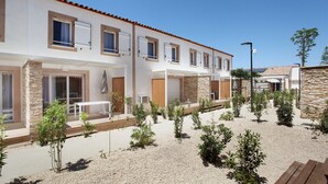Un hôtel moderne doté de nombreuses chambres, d’un espace extérieur aménagé pour se détendre et d’un jardin bien entretenu.