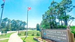 Ein Schild für den Topsail Hill Preserve State Park, mit einem gut sichtbaren Weg zum Eingang.