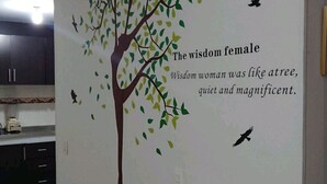 A wall with a tree mural and a quote about wisdom. - Nice Chia Apartment (Chía)