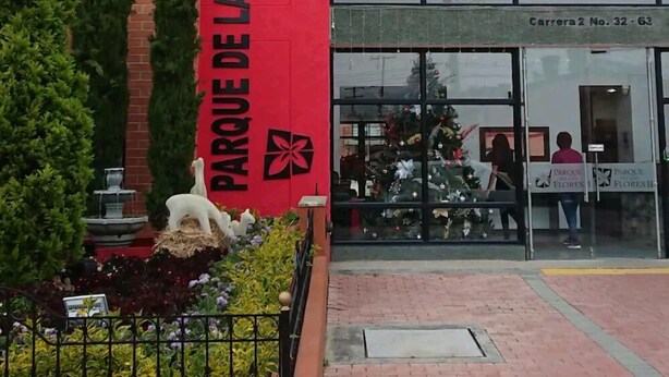 A building with a red facade and a large glass entrance. - Nice Chia Apartment (Chía)