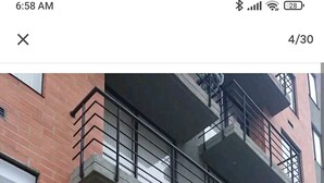 A multi-story building with a brick facade, numbered 11, featuring balconies with railings and potted plants. - Nice Chia Apartment (Chía)