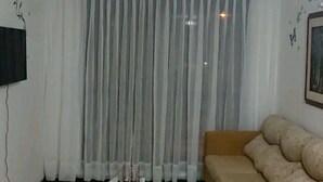 A living room with a sofa, a coffee table, a TV, and a window with curtains. - Nice Chia Apartment (Chía)