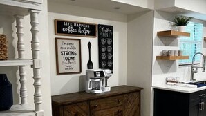 Eine Küche mit Holzschrank, Kaffeemaschine und Wanddekoration.