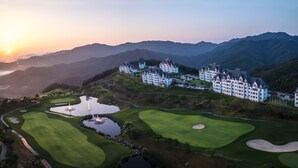 A golf course with a large building complex in the background. - Sono Felice Village Vivaldi Park (Hongcheon)
