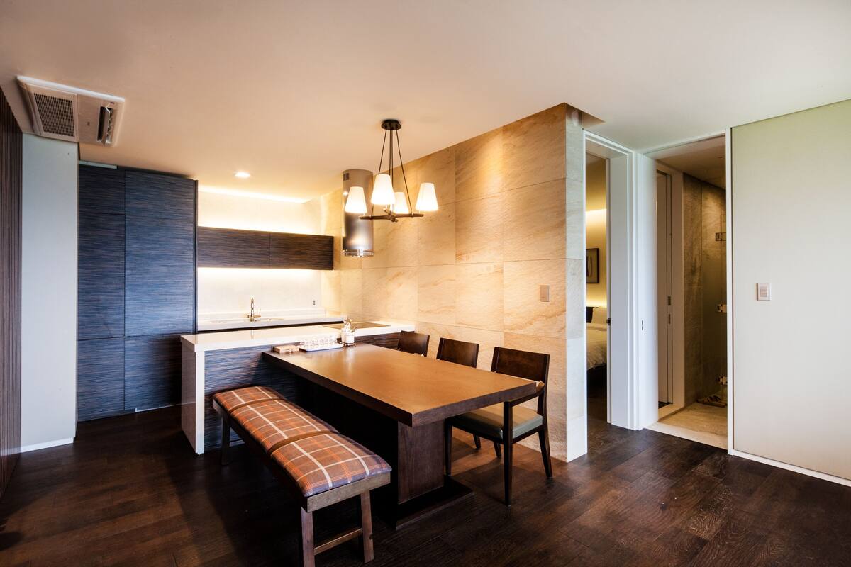 A modern kitchen with a central island, bench seating, and a pendant light.