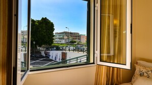 Ein Zimmer mit großem Fenster mit Blick auf einen Parkplatz und Gebäude.
