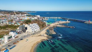 A coastal town with a beach, a pier, and a lighthouse. - Gosung Stager (Goseong)