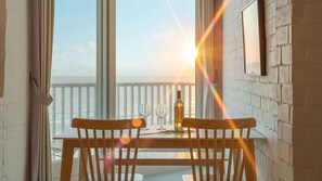 A balcony with a table and chairs, a bottle of wine, and a glass. - Gosung Stager (Goseong)