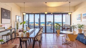 A beachfront restaurant with a long dining table, chairs, and potted plants. - Gosung Stager (Goseong)