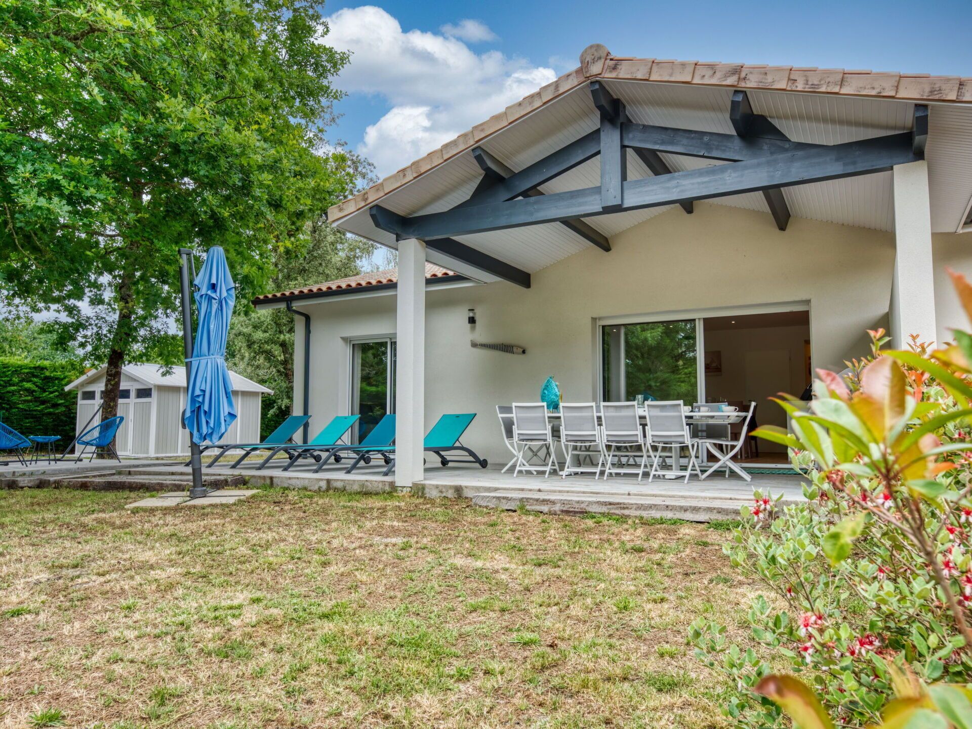 Un patio extérieur moderne doté d’un espace salon couvert, d’une table et de chaises.