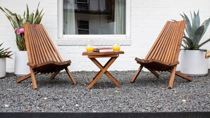 Two wooden lounge chairs, a small table with books and drinks, and potted plants against a white brick wall. - Newly Renovated Modern Condo- Walk to Zilker & Barton Springs! Private backyard! (Austin)