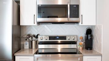 A modern kitchen with stainless steel appliances including a microwave, oven, and coffee maker.