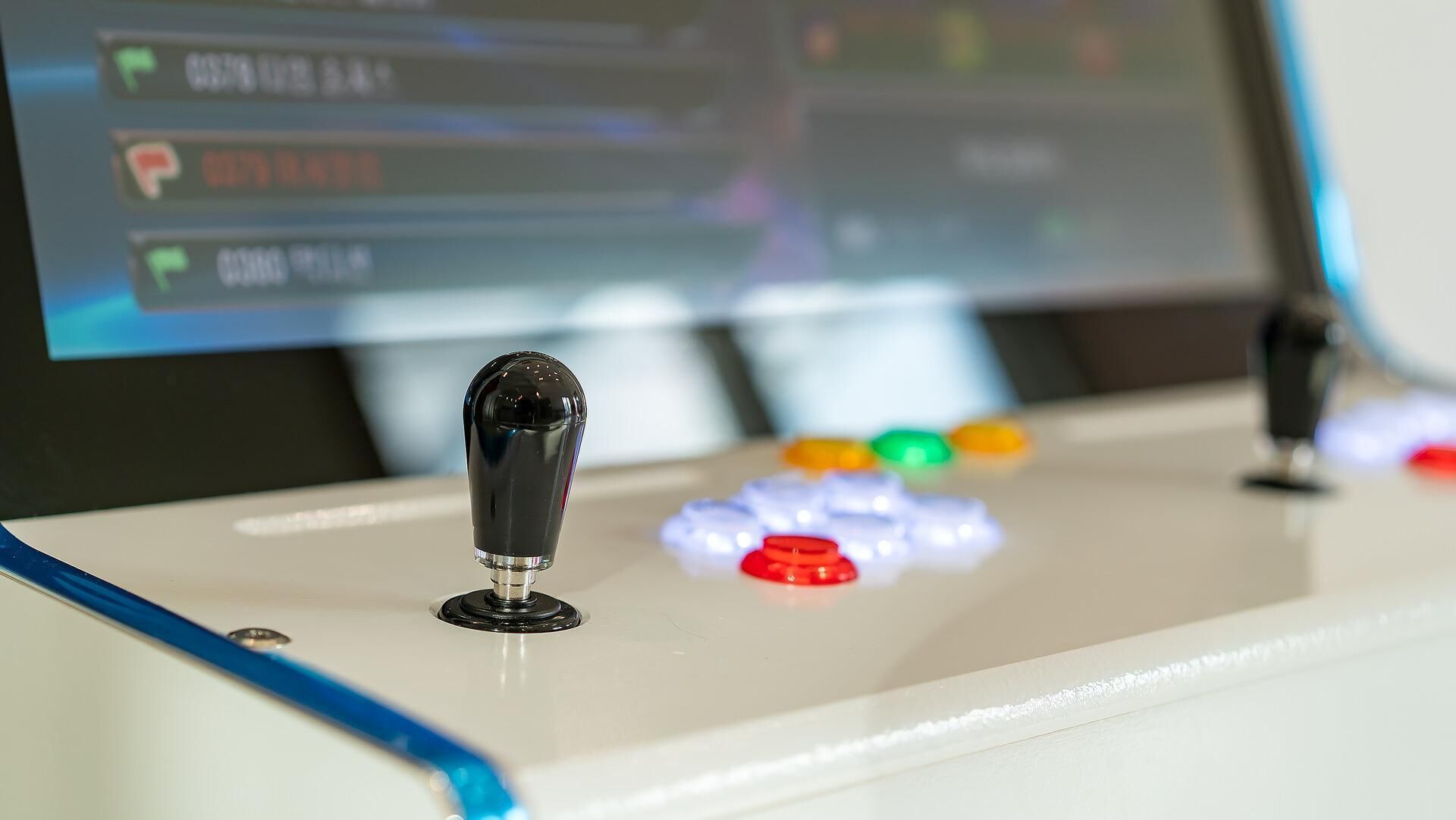 A control panel with a joystick and colorful buttons, likely part of a gaming setup.